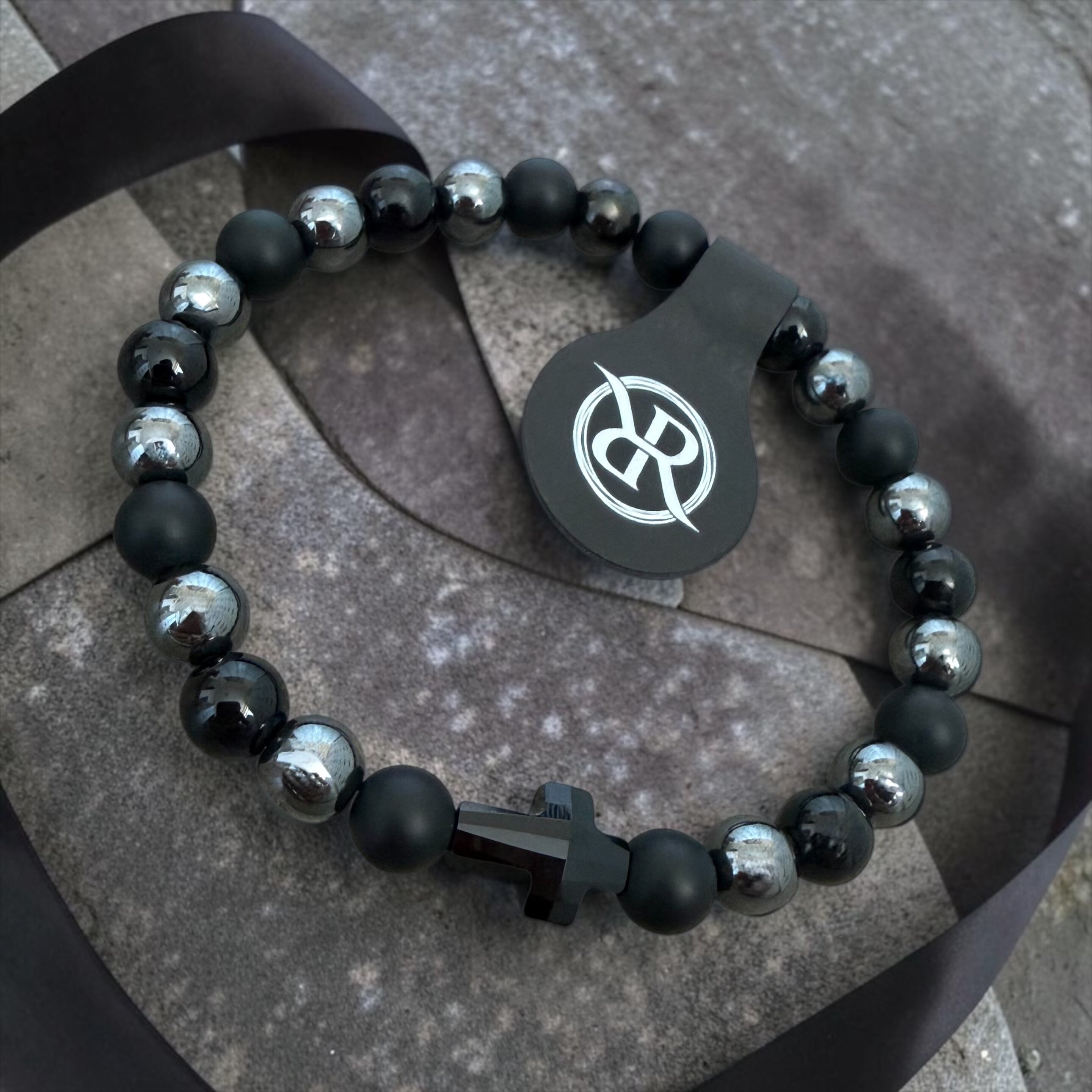 A bracelet made from natural onyx and haematite stones with a black Swarovski cross