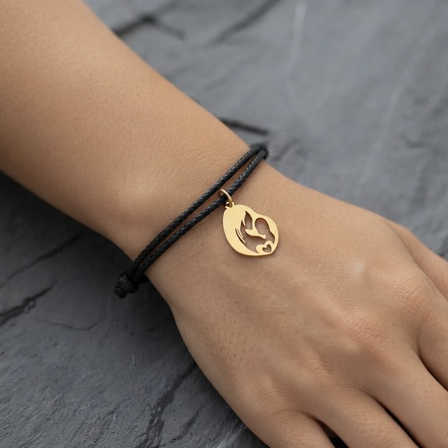 A minimalist ‘Bond of Love’ bracelet with a gold pendant featuring a woman and a small child