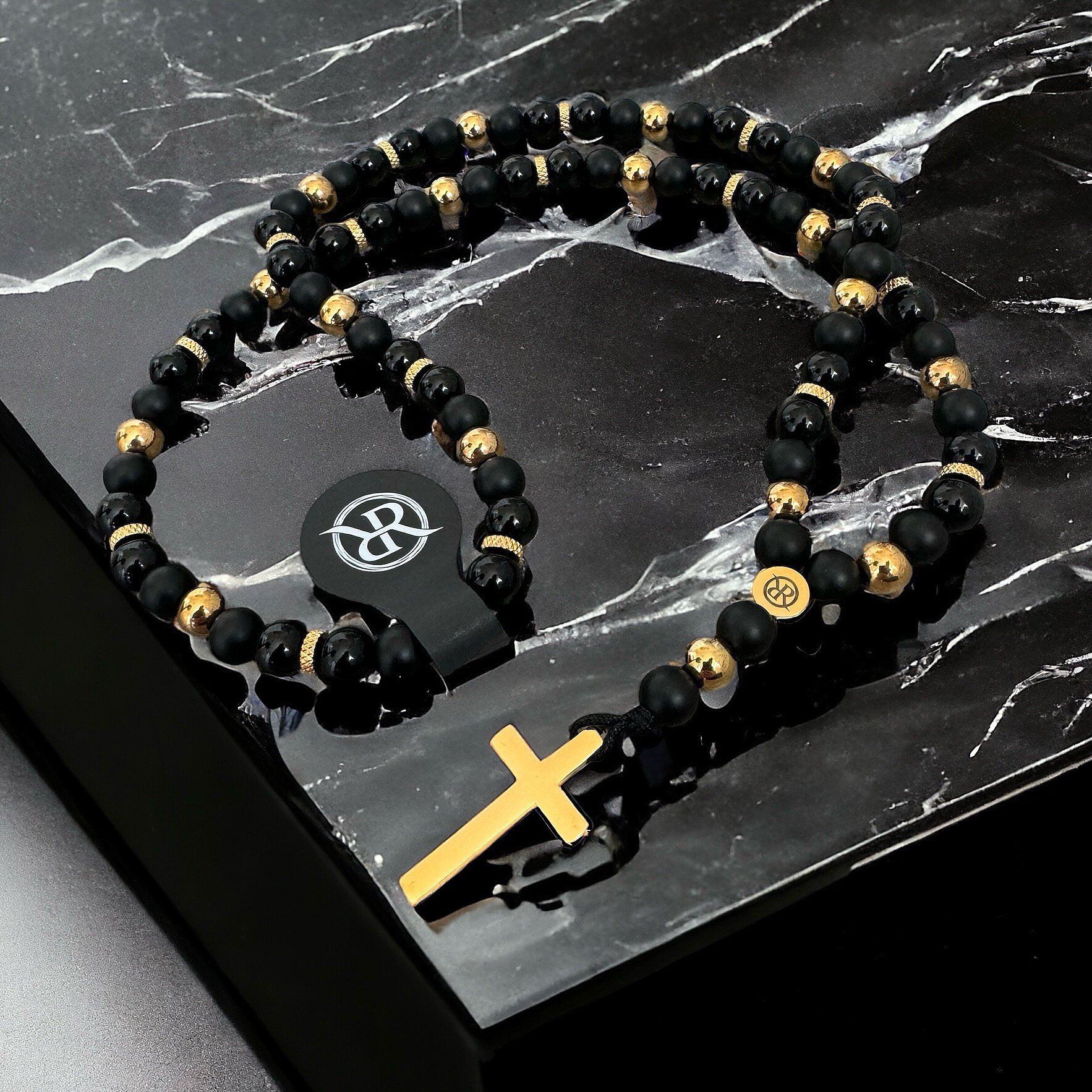 Necklace in the shape of a rosary made of natural stones with a gold cross