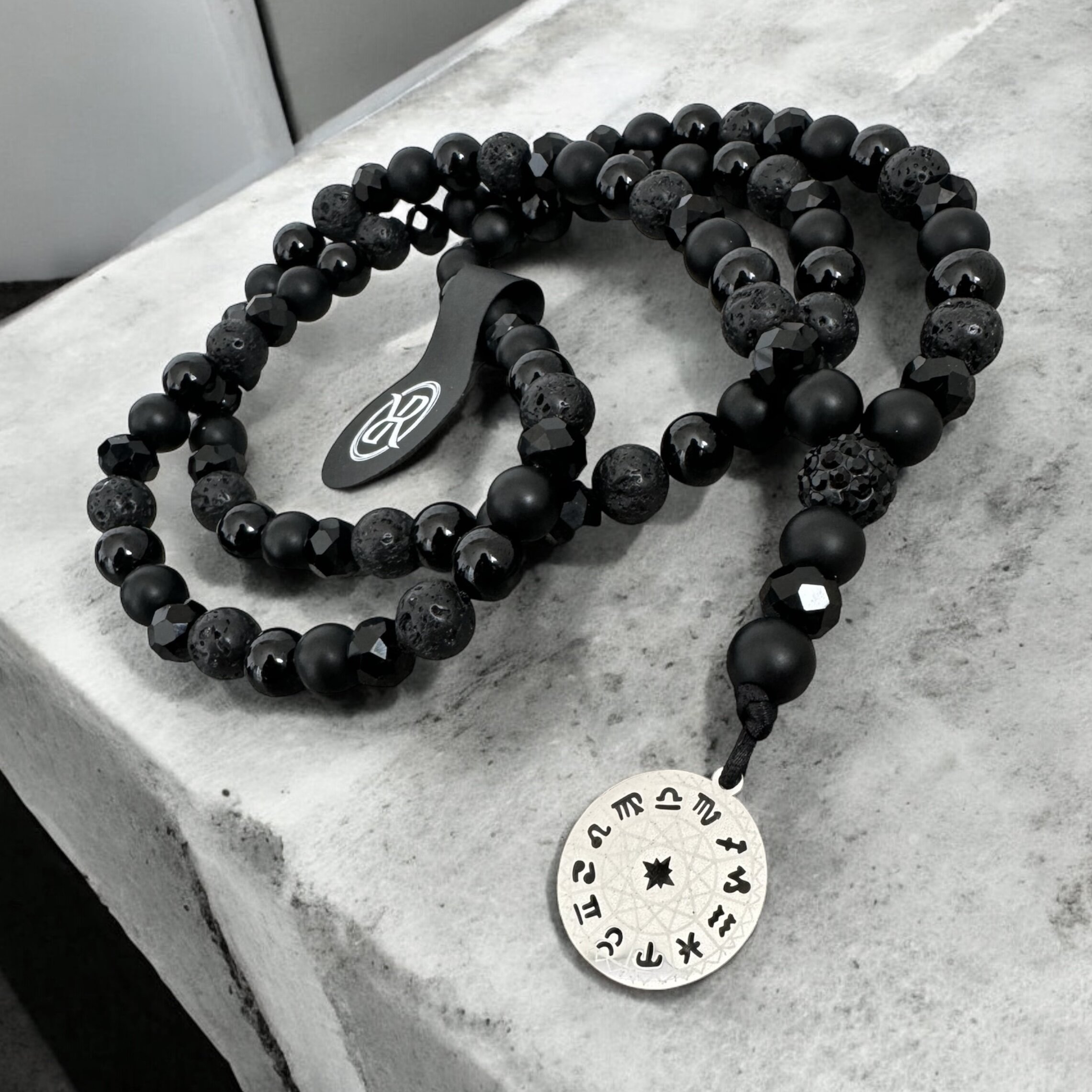 Necklace in the shape of a rosary made of natural stones with a medallion with zodiac signs