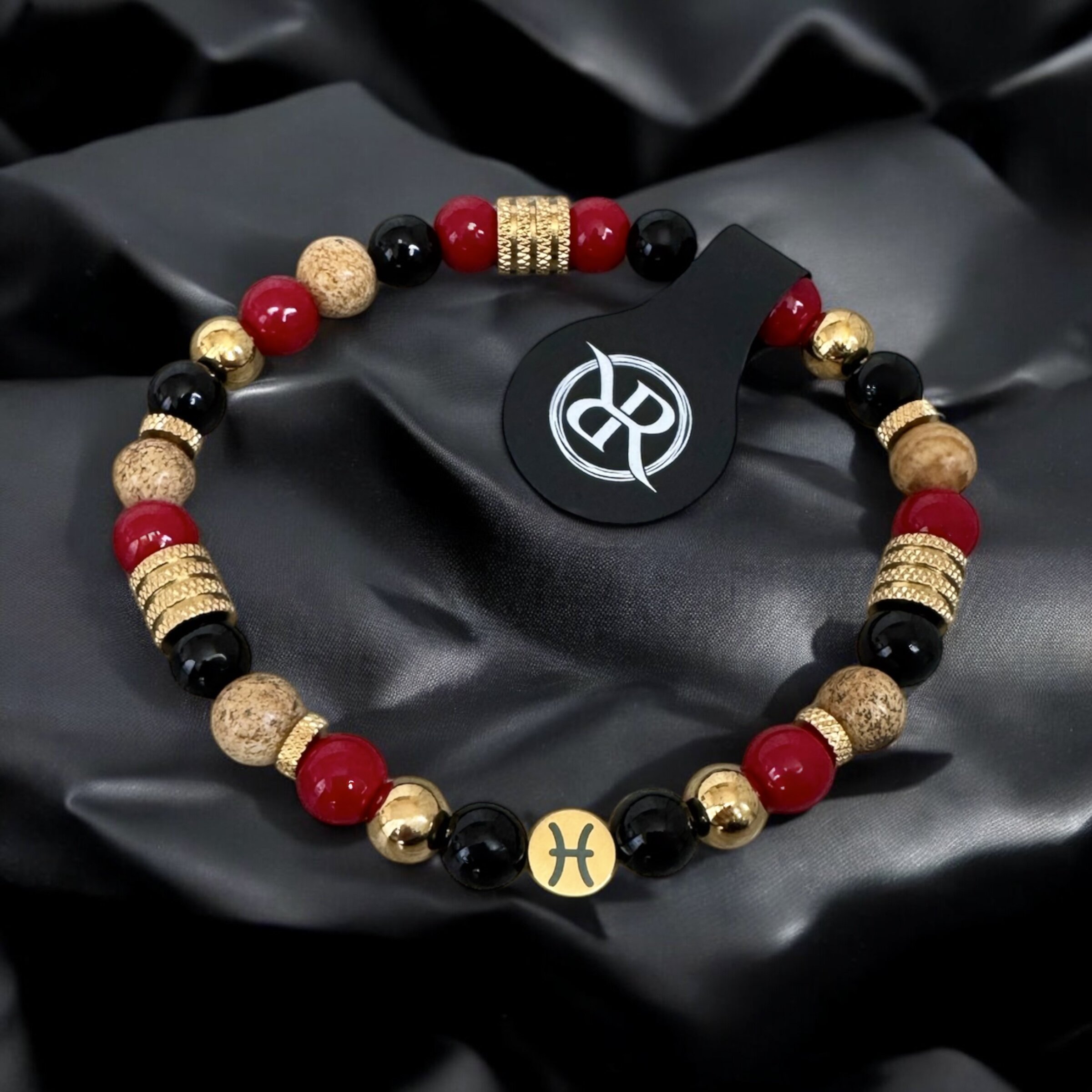 Protective energy bracelet featuring a zodiac sign, made from red coral, onyx and jasper